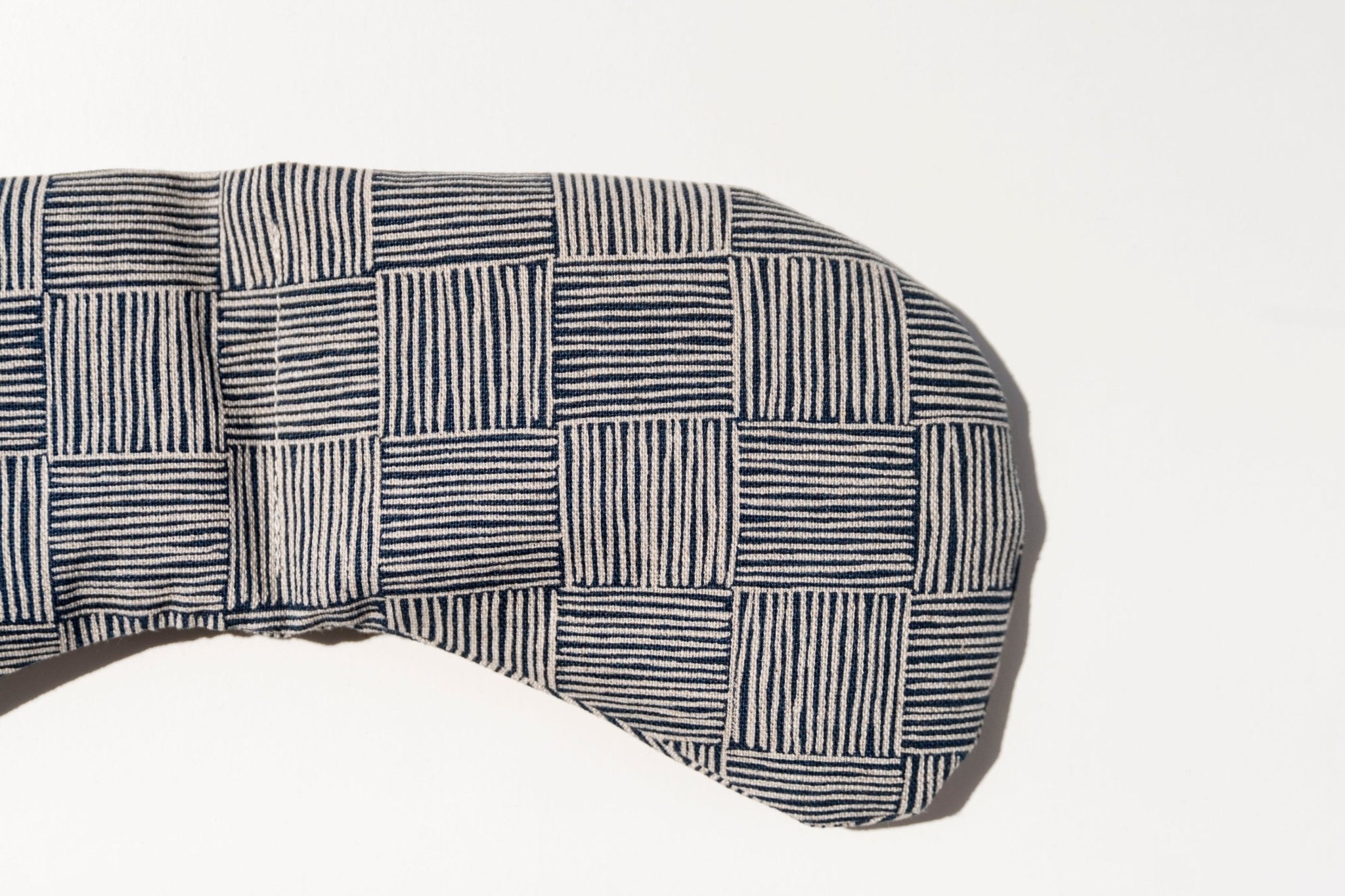 Migraine relief eye mask featuring a neutral textural pattern designed for headache and tension relief.