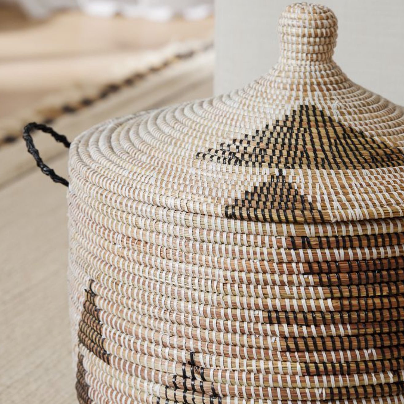 Large graphic print storage basket with black and white woven design, handcrafted from millet grass and recycled plastic.
